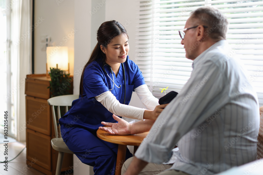 Obraz premium The doctor or Nurse is examining an elderly patient. Friendly nurse or physician in blue scrubs looking at old man at home.