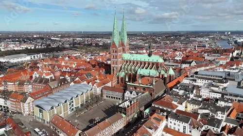 Aerial view of a historic city with twin-spired church  of  Lubeck, Germany and red-roofed buildings.