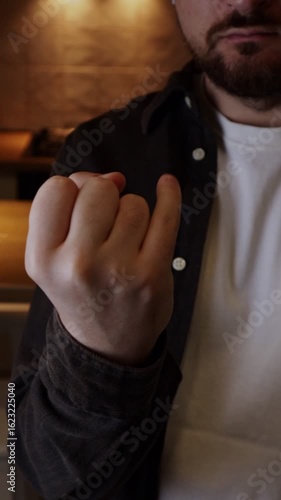 Man showing pinky finger insulting other man meaning he is weak or have a small penis