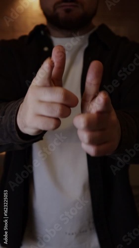 Man pointing fingers at the camera holding hands as guns pretending like he's shooting meaning you've got this