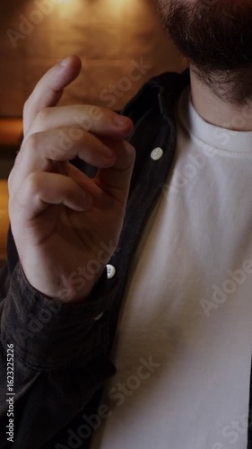 Man in a casual outfit snaps his fingers, clicks meaning 