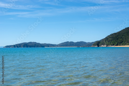 Serene Beach with Turquoise Waters and Distant Mountains