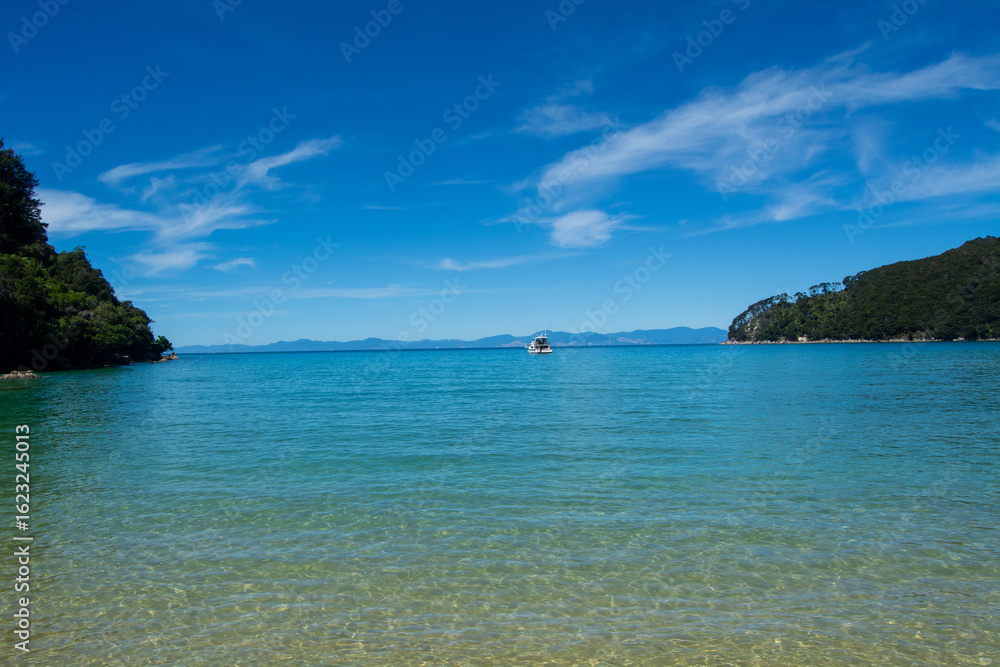 Fototapeta premium Serene Beach with Turquoise Waters and Distant Boat