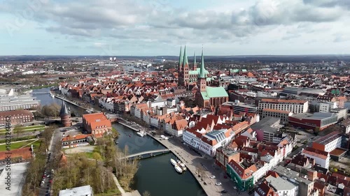 Aerial view of a historic European city of Lubeck, Germany with prominent twin-spired cathedral and red-roofed buildings.