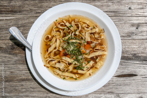 a soup (Frittatensuppe) served on a white plate at a mountain hut 
