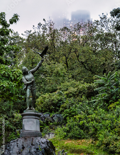 The Falconer statue in Central Park with foggy building in background
