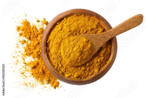Overhead view of turmeric powder in a wooden bowl with a wooden spoon