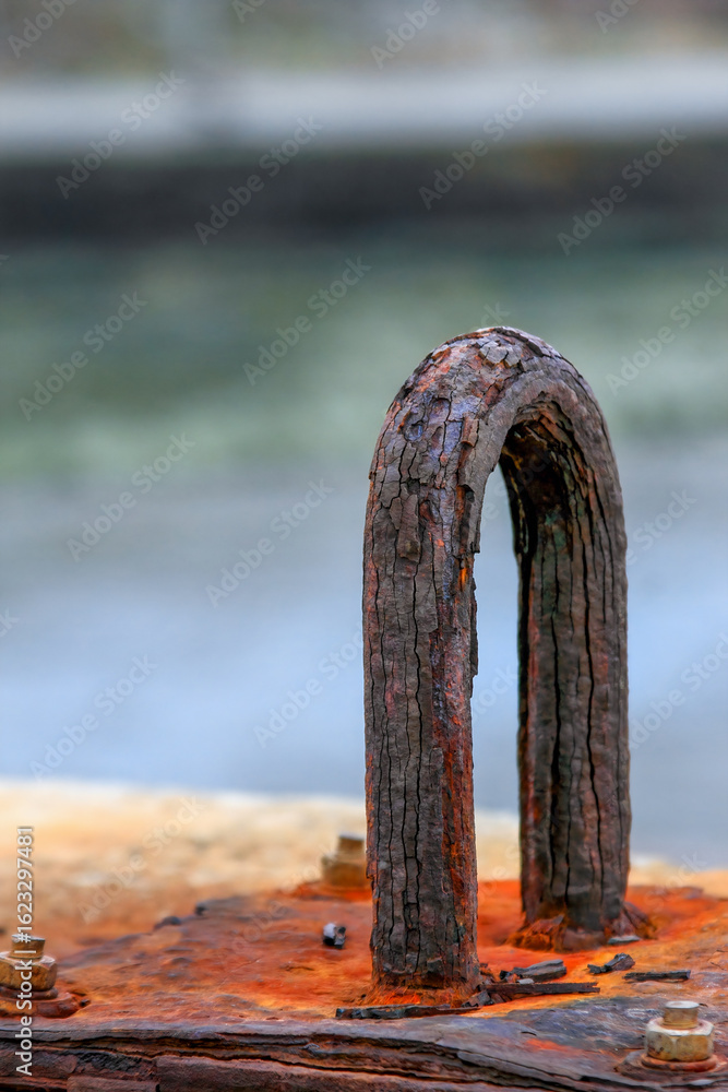 Fototapeta premium Close-up of a weathered rusty anchor at Longgang in Houlong, Miaoli, Taiwan, against a blurred waterfront background, showcasing industrial decay and texture.