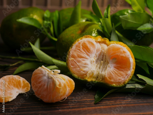 Jeruk keprok, fresh tangerines with green leaves on wooden table, fresh orange fruit, ripe tangerine, jeruk mandarin, delicious, healthy
