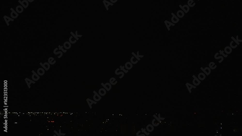 Night thunderstorm with striking lightning in dense clouds