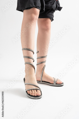 Sandalias brillantes con pedrería atadas al tobillo, ideales para el verano.