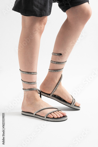 Sandalias brillantes con pedrería atadas al tobillo, ideales para el verano.