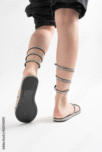 Sandalias brillantes con pedrería atadas al tobillo, ideales para el verano.