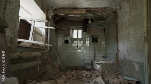 A residential building damaged by shelling, view from inside. Debris, broken walls. Tragic aftermath of war in Ukraine. Traces of destruction and violence.
