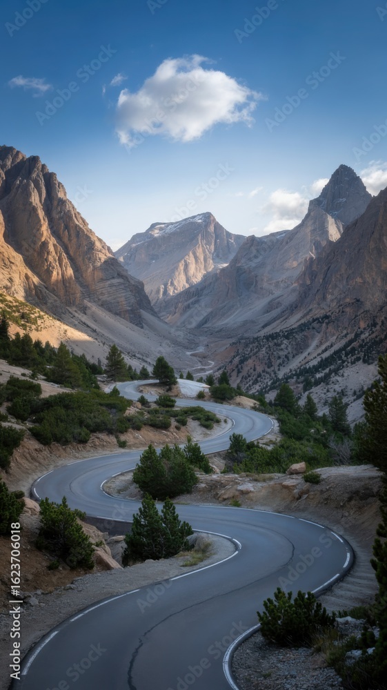 Fototapeta premium Winding road through a majestic mountain valley under a cloudy sky