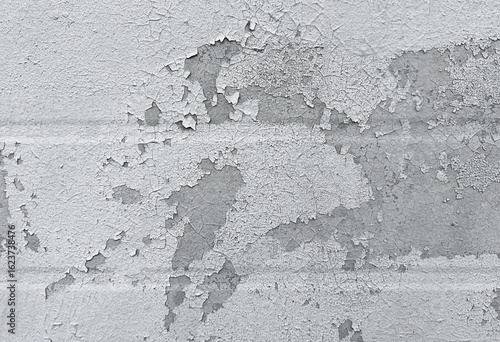 Peeling flaking paint on gray concrete wall. Cracked coating texture background. Dirty grunge surface backdrop. Repair concept.