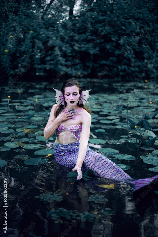 Fototapeta premium Mermaid lounging in serene pond surrounded by lily pads on a peaceful afternoon