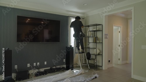 Handiman installing curtains in a luxury home