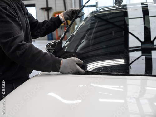 Billede på lærred Mechanic performing windshield installation or repair work on vehicle in profess