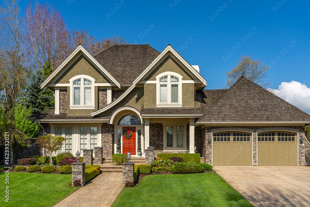 Obraz premium Two story stucco luxury house with nice spring blossom landscape in Vancouver, Canada, North America. Day time on May 2025.
