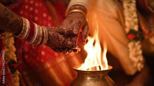 Dulhan radiant in her finery offers sacred rice with her groom in a hindu wedding fire ceremony. Ideal for wedding, cultural, and festive concepts.