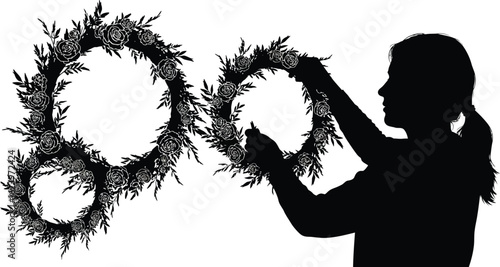 Vector art of a silhouette of a woman arranging floral wreaths isolated on white background, showcasing her creativity and artistic touch
