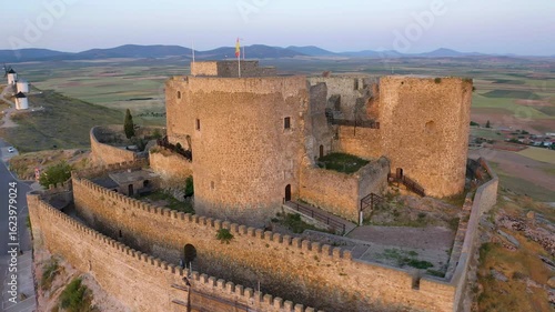 Aerial view of sunrise over the Medieval Castle of Consuegra and his windmills in Toledo, Spain.