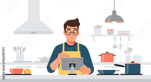 Man Cooking Looking At Tablet For Recipe In Modern Kitchen Setting