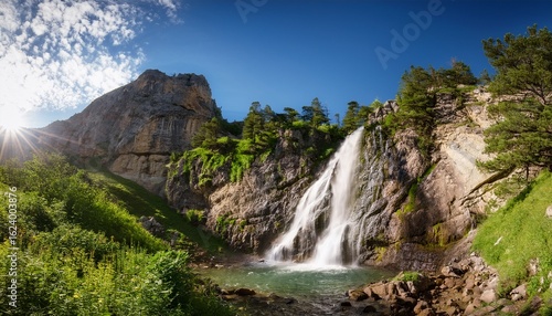 scenic waterfall cascading down rocky cliffs surrounded by lush green vegetation on a sunny day forming a picturesque mountain landscape