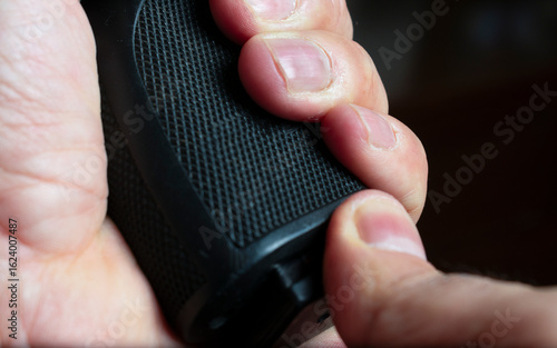 Mature Man Loading a Semi-Automatic Pistol Magazine