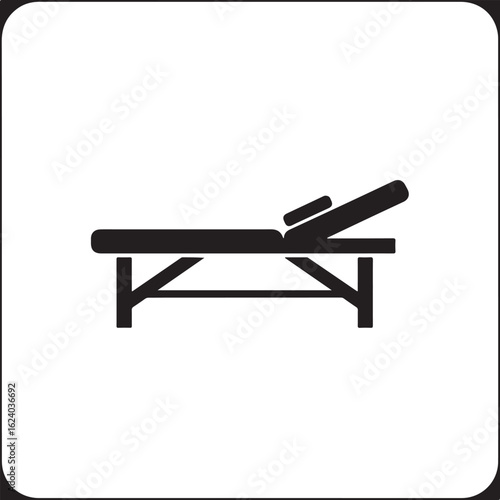 Black icon of a massage table with adjustable headrest spa table therapy table