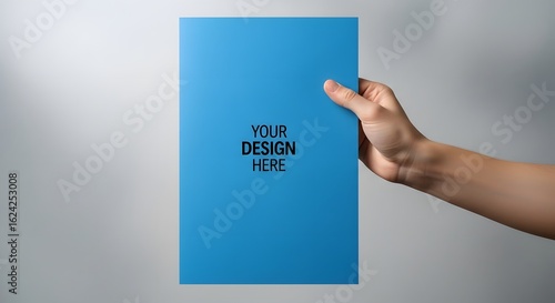 Hand holding a blank blue A4 paper mockup. A versatile template concept for showcasing your flyer, poster, or brochure design.