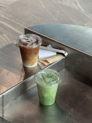 two cups of ice latte and mathca latte on table