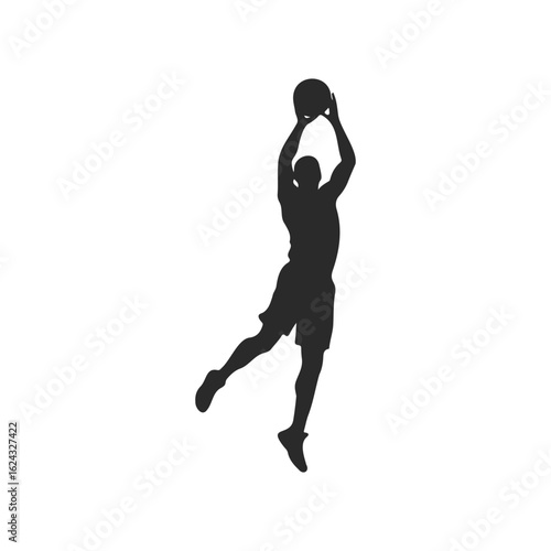 Silhouette of male basketball player dunking ball in mid-air