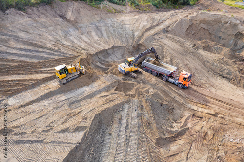 aerial view of quarry. excavator loading sand into dump truck