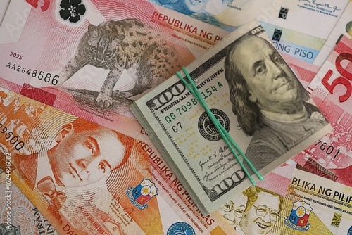 Philippines peso currency money bills and bunch of us dollar banknotes. The concept of economics and currency exchange