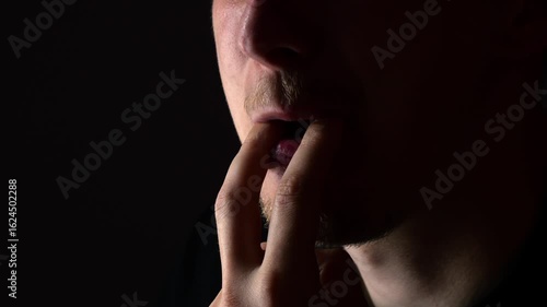 Close-up of a man's mouth whistling on a black background.
Man whistling and creating sound with lips and mouth.
Ringing and loud whistling with mouth.
Man's lips imitating whistling