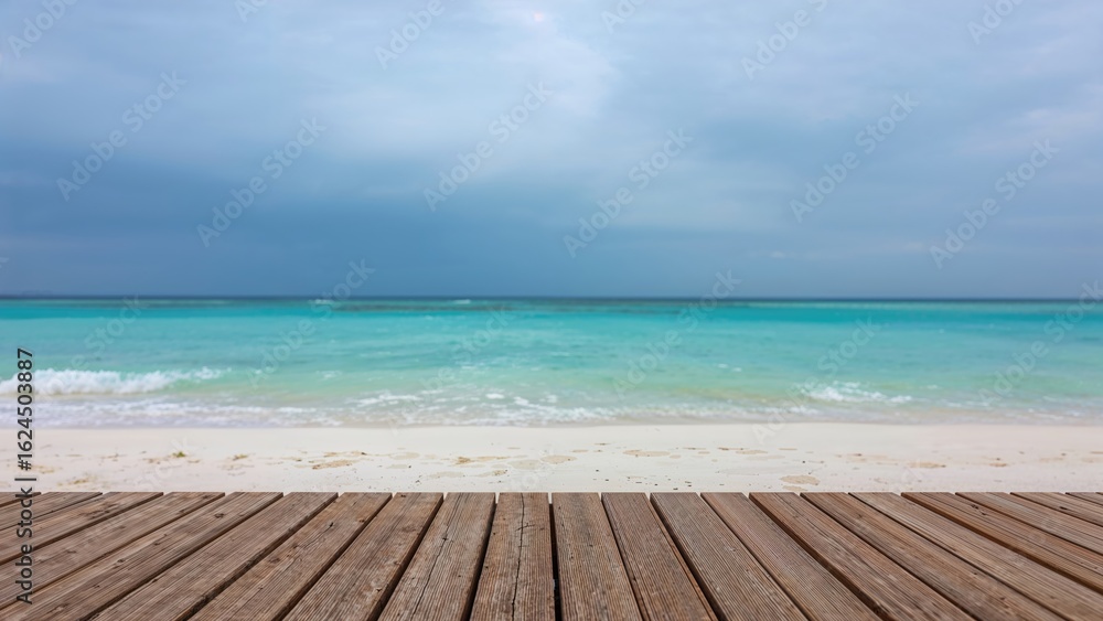 Fototapeta premium In warm weather, an attractive shoreline with white sand stretches out. The sky shows an overcast blue tone, and the water gleams turquoise. Holiday backdrop with natural scenery, blurred effect, and