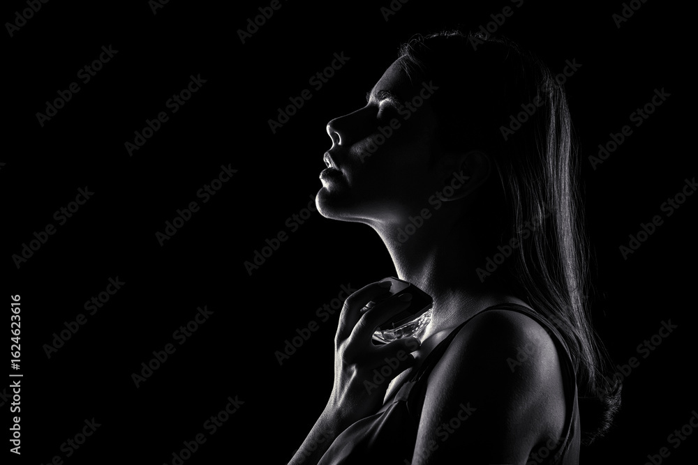 Obraz premium Womens with perfume bottle. Girl holding a perfume bottle. Beautiful girl using perfume. Woman with bottle of perfumes. Black and white