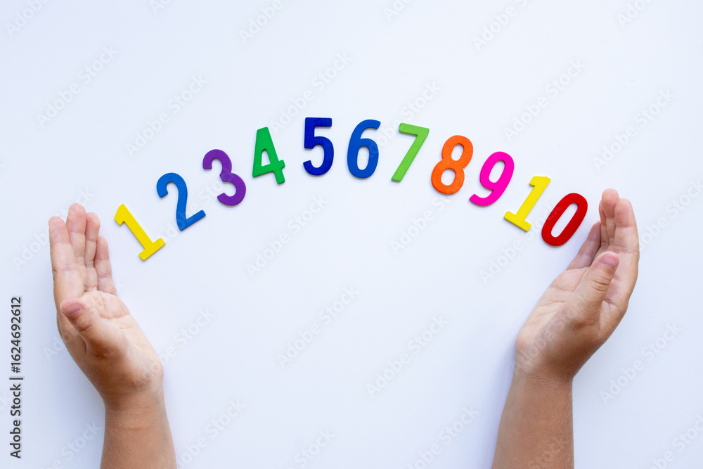 Fototapeta premium Child hands display colorful numbers 1 to 10 on white background