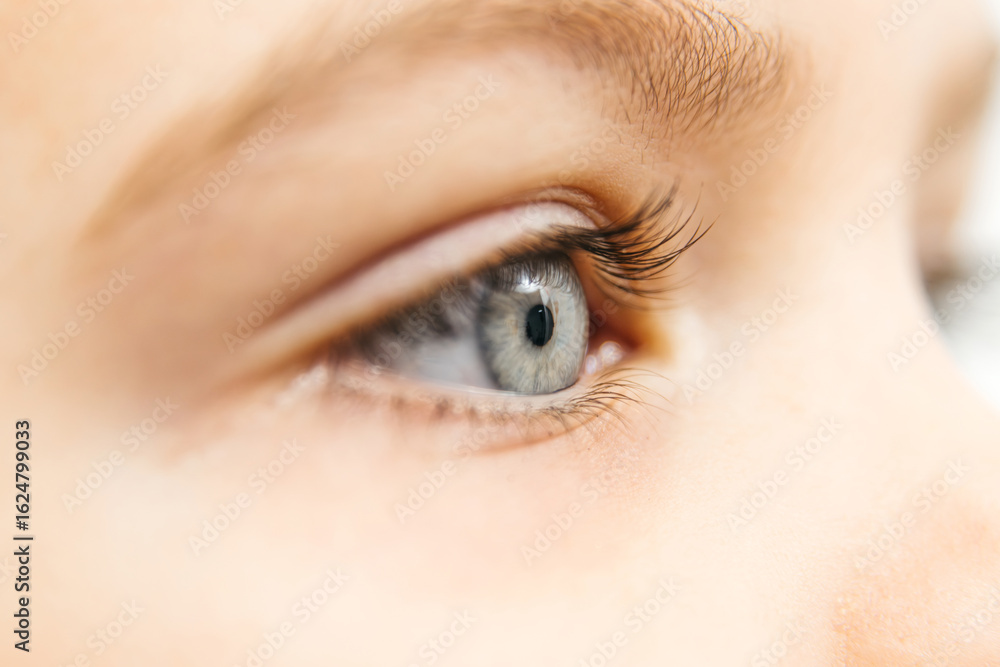 Obraz premium Close-up of a child's eye showcasing vibrant blue iris and long eyelashes, highlighting the intricate details of vision, emphasizing the importance of eye health and vision testing in ophthalmology