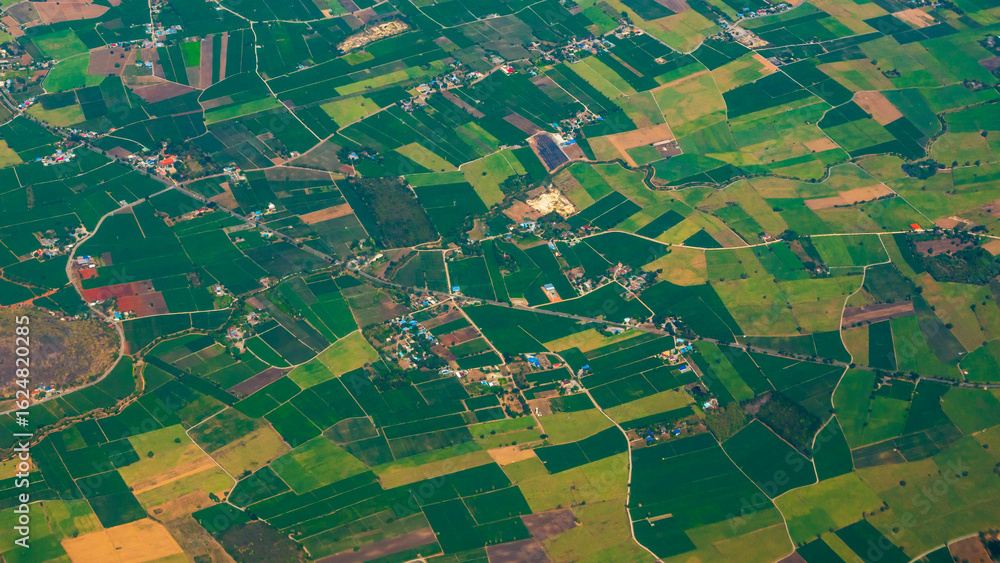 Obraz premium Aerial view Green paddy rice terrace land. Aerial drone shots summer tropical in summertime on sunny day amazing landscape. Agriculture rice field above view greenery background natural paddy fields