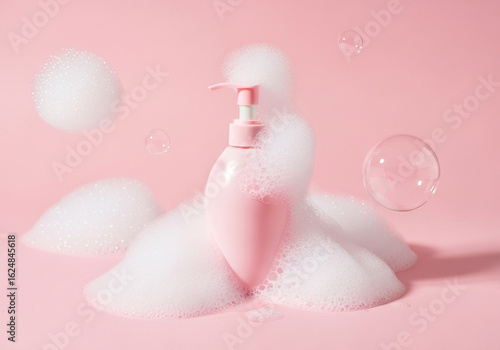 Pink soap dispenser bottle in fluffy white foam, pastel pink background, clean and fresh.