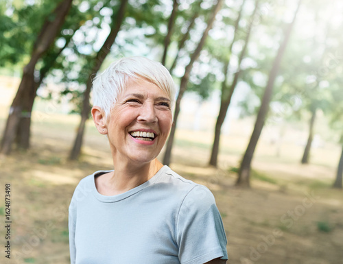 Portrait of a happy active senior woman posing after exercising outdoors