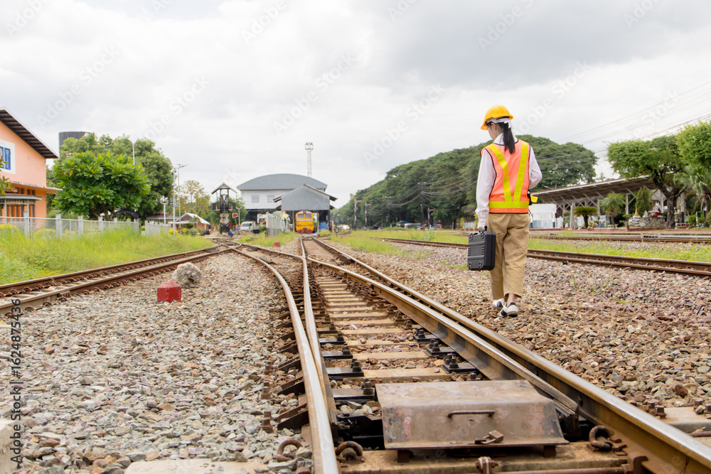 Fototapeta premium Asian young teen train engineer work check inspect service maintenance old locomotive railway track