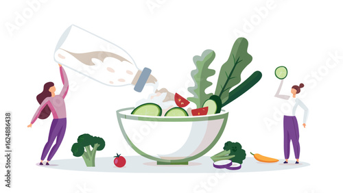 Woman pouring dressing on a salad with another woman holding a cucumber slice and vegetables around