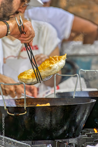 Scolatura della torta fritta in una sagra paesana