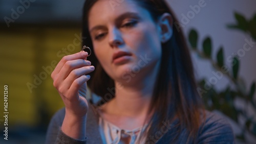 Fotografie Caucasian woman sad at home night evening upset take off wedding ring frustrated