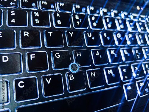 Backlit laptop keyboard with glowing illuminated keys in the dark