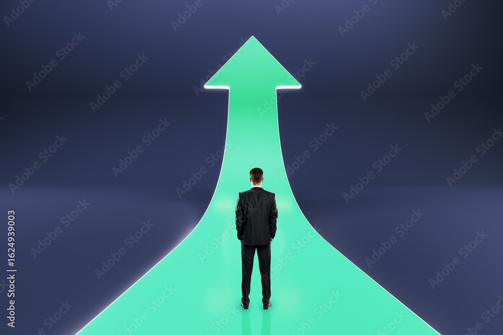 Fototapeta premium Businessman standing on glowing green upward arrow path symbolizing career growth, leadership vision, and future success on dark background.